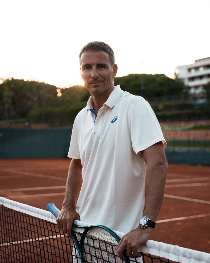 A man at the net on a clay tennis court